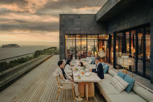 a group of people sitting at a table on a balcony at JW Marriott Jeju Resort & Spa in Seogwipo