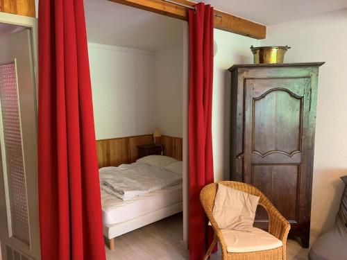 une chambre avec un lit et un rideau rouge dans l'établissement T2 Cabine 6 pers avec parking, face aux pistes - Enchastrayes - FR-1-165A-189, à Enchastrayes