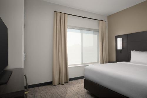 a bedroom with a bed and a large window at Residence Inn by Marriott Fresno Clovis in Clovis
