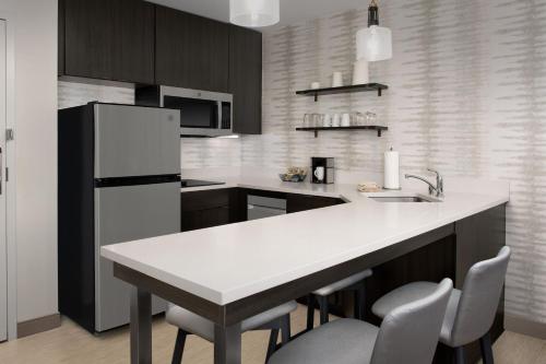 a kitchen with a white counter and a refrigerator at Residence Inn by Marriott Fresno Clovis in Clovis