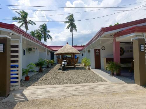 a house with a motorcycle parked in the courtyard at 3 Sisters Guest House 1 in Moalboal