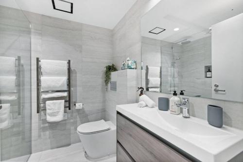 a bathroom with a sink and a toilet and a mirror at Wanaka Station Apartment in Wanaka