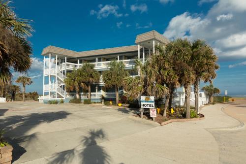 a large white building with palm trees in front of it at The Saint Augustine Beach House in Saint Augustine