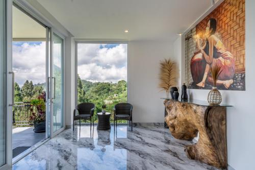 a living room with a table and chairs and a large window at Adara Lake View Residence Bedugul - Bali in Bedugul