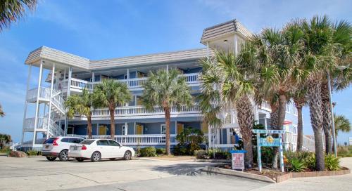 a white building with palm trees in front of it at The Saint Augustine Beach House in Saint Augustine
