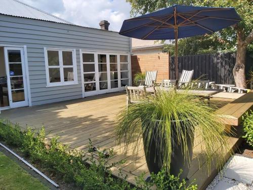 a patio with a table and an umbrella at Grafton House Villa Oasis, Central Auckland in Auckland