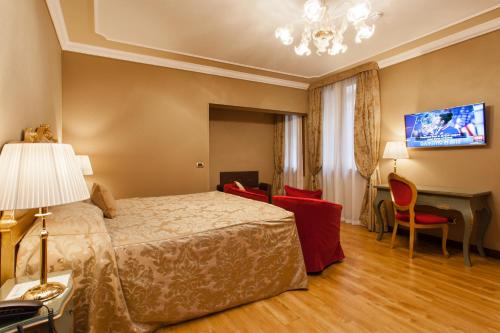 a hotel room with a bed and a desk at Hotel Al Ponte Mocenigo in Venice