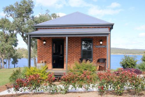a red brick house with a view of the water at Dusty Hill Vineyard - Moffatdale in Moffatdale