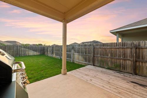a backyard with a wooden fence and a patio umbrella at Elegant Home with Cozy Vibes in Pflugerville