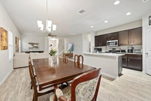 a kitchen and dining room with a wooden table at Elegant Home with Cozy Vibes in Pflugerville