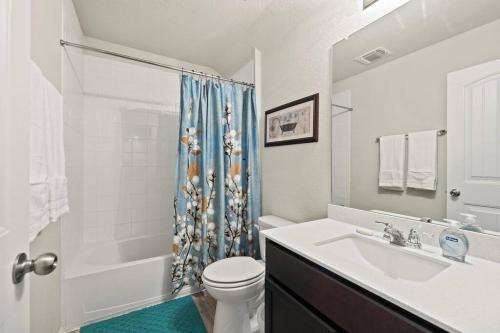 a bathroom with a sink and a toilet and a shower at Elegant Home with Cozy Vibes in Pflugerville