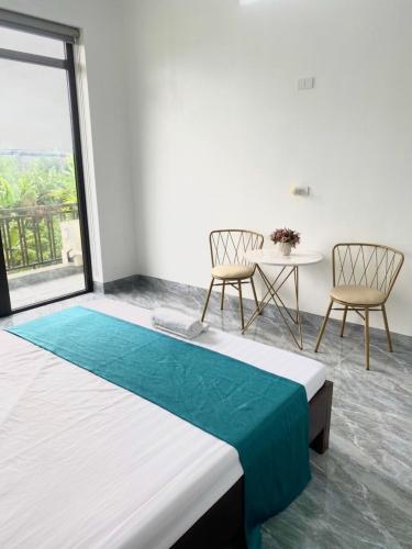 a bedroom with a bed and two chairs and a table at Khách Sạn HƯƠNG HANA in Phúc Trì