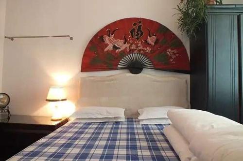 Dormitorio con cama con colcha a cuadros en Luoyang Jujia Hostel, en Luoyang