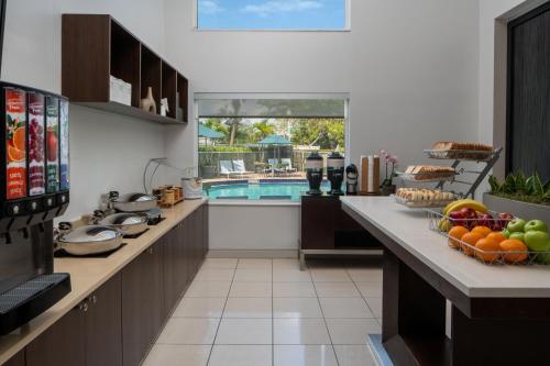 Una cocina con una piscina y una mesa con fruta encima. en SpringHill Suites Fort Lauderdale Airport, en Dania Beach