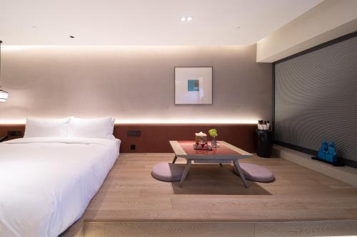 a bedroom with a bed and a table in it at Qianzitong First Seeing Hotel in Changping