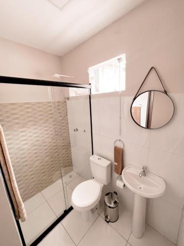a bathroom with a toilet and a sink and a mirror at Villa Santiago II in Manaus