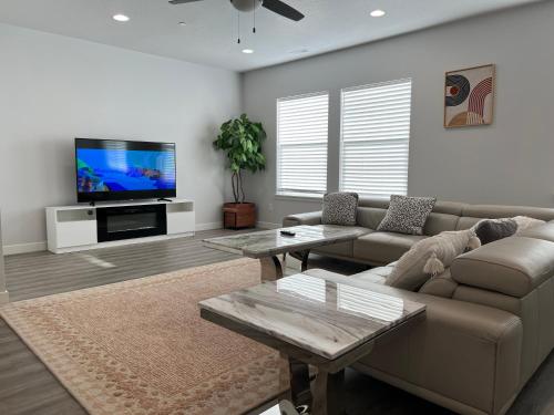 a living room with a couch and a flat screen tv at Modern Town House, 3-Bedrooms Home private parking in Draper
