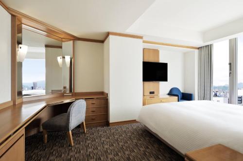 a hotel room with a bed and a desk and a television at Fairfield by Marriott Sapporo in Sapporo