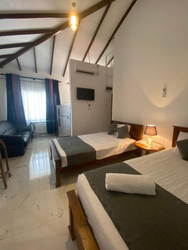a large room with two beds and a couch at Serendib Villa in Negombo