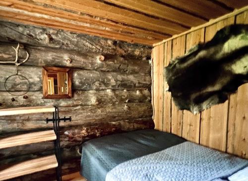 a room with a bed in a log cabin at Lapland Lodge Pyhä Ski in, sauna, free WiFi, national park - Lapland Villas in Pyhätunturi