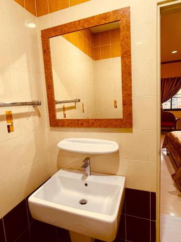 a bathroom with a white sink and a mirror at Mini Cost Apartment&Guesthouse in Chiang Mai