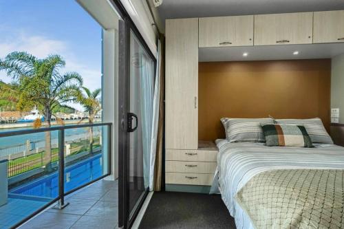 a bedroom with a bed and a view of the ocean at NEW! 600m to CBD - Pool in Gisborne