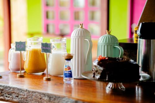 eine Theke mit vielen verschiedenen Arten von Gläsern mit Lebensmitteln in der Unterkunft Pousada Villa Tainá - Arraial d'Ajuda, Bahia in Arraial d'Ajuda