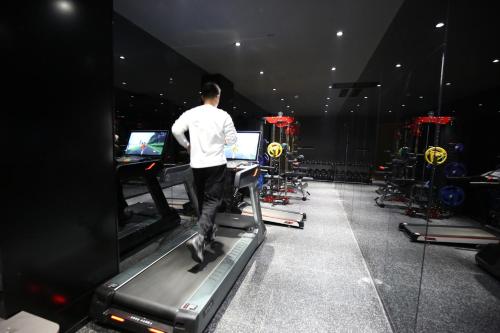 a man running on a treadmill in a gym at Qianzitong First Seeing Hotel in Changping