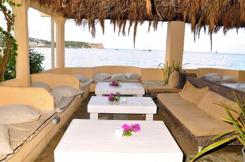 a living room filled with furniture next to a beach at Hostal Talamanca in Talamanca
