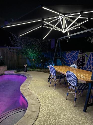 a patio with a table and chairs and a pool at Serene 4BR Lux Home w Heated Spa Pool Massage Chair in Cypress