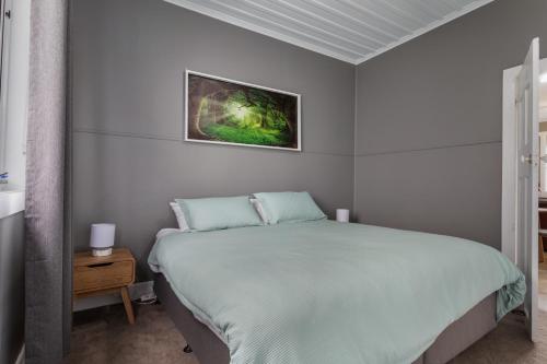 a bedroom with a bed and a painting on the wall at Celtic Cottage, Scottsdale in Scottsdale