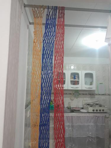 a kitchen with red white and blue curtains on the window at MANOA "Lugar de descanso" HABITACION CON VISTA A LA CIUDAD, FRESCO Y VENTILADO in Ibagué