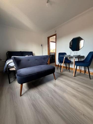 a living room with a blue couch and a desk at Vibrant City Center Studio Apartment 6a in Norwich