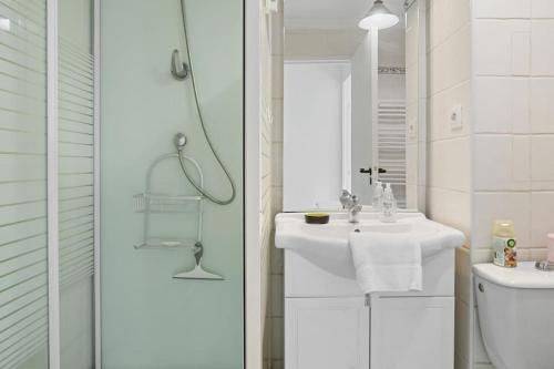une salle de bain blanche avec un lavabo et une douche dans l'établissement Joli 32m2, piscine, parking, Wifi, à Fréjus