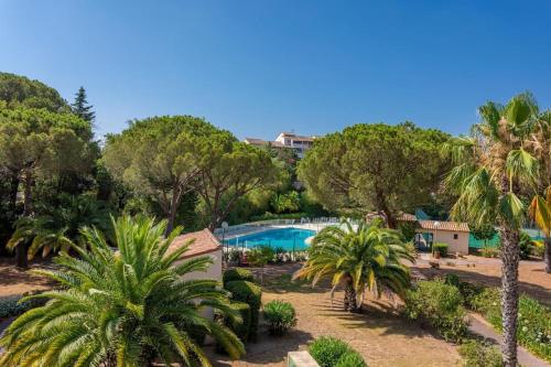 un complexe avec piscine et palmiers dans l'établissement Joli 32m2, piscine, parking, Wifi, à Fréjus