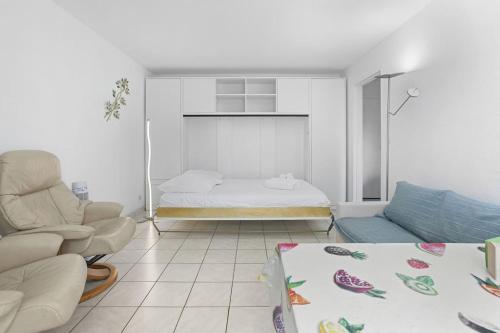 un salon avec un lit et un canapé dans l'établissement Joli 32m2, piscine, parking, Wifi, à Fréjus