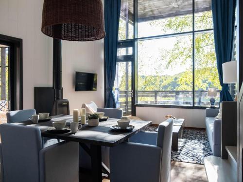 a dining room with a table and chairs and a large window at Elegant Mansion with Pools in Antoing