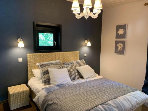 a bedroom with a bed with pillows and a chandelier at Forest-View Mansion, Hainaut in Antoing
