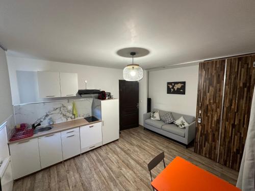 une cuisine et un salon avec un canapé et une table dans l'établissement Appartement privé dans villa, à Montauban