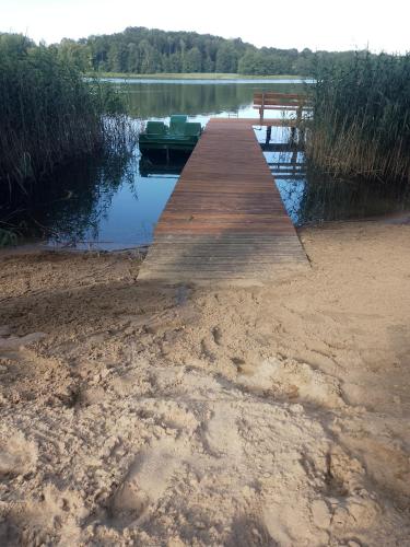 a dock on the shore of a body of water at Dom nad jeziorem in Sorkwity