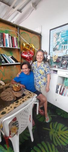 two women sitting at a table in a room at MANOA "Lugar de descanso" HABITACION CON VISTA A LA CIUDAD, FRESCO Y VENTILADO in Ibagué