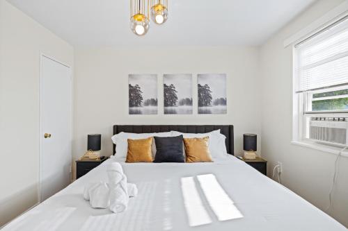 a white bedroom with a large white bed with pillows at --Free Parking & 2 King Beds -- Vintage Retreat -- Floyd's Freedom in Alexandria
