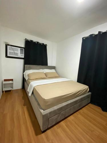 a bed in a room with black curtains at JM Transient House in Butuan