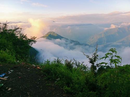 a view of a mountain with clouds in the valley at Burans Breeze in Dhanaulti