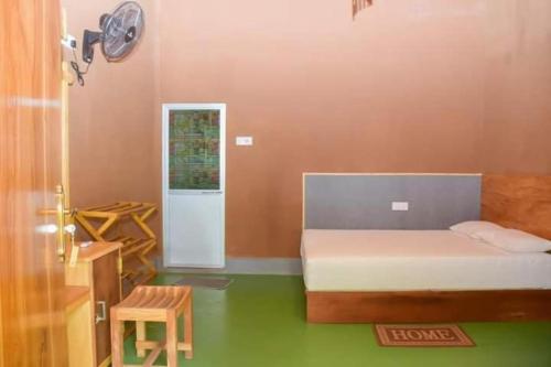 a bedroom with a bed and a table and a clock at Kirindioya Village Safari Lodge in Tanamalwila