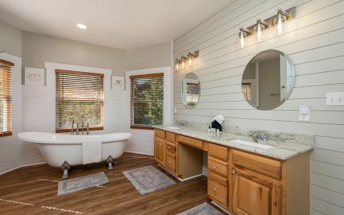 赛维尔维尔Shadow Ridge Retreat的白色的浴室设有浴缸和两个盥洗盆