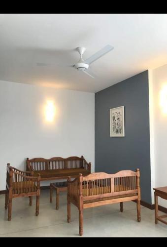 three wooden benches in a room with a ceiling at Manthila Resort Rajarata in Anuradhapura