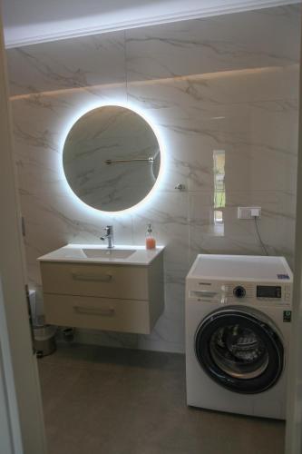 a bathroom with a sink and a washing machine at Nicole Fresh Apartments in Keramoti