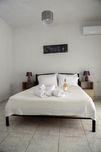 a bedroom with a white bed with two towels on it at Nicole Fresh Apartments in Keramoti