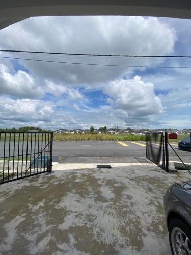 an empty parking lot with a gate and a street at Ikhwan HOMESTAY CHERATING in Kampong Baharu